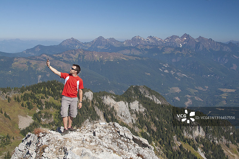 男子在山区徒步旅行时寻找手机信号图片素材