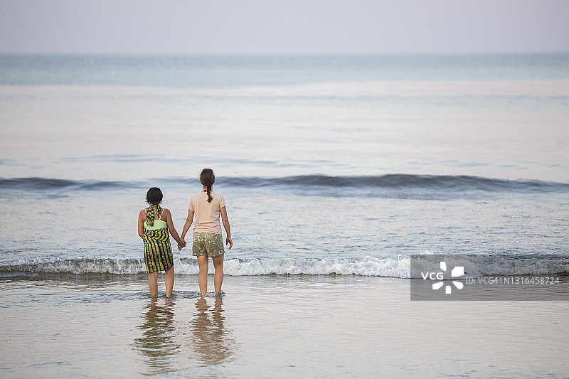 海滩边，母女手牵手背影图片素材