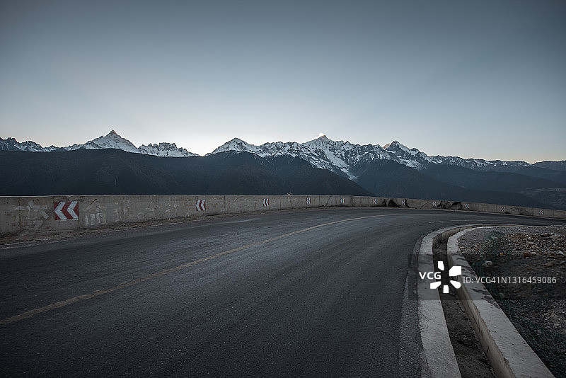 通往雪山的藏族聚居区高原上的空旷道路图片素材