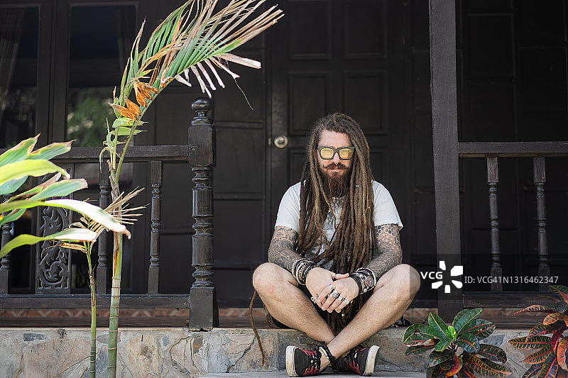 在泰国海滩上留着脏辫和纹身的时尚男士图片素材