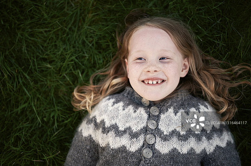 快乐的女孩在草地上放松图片素材