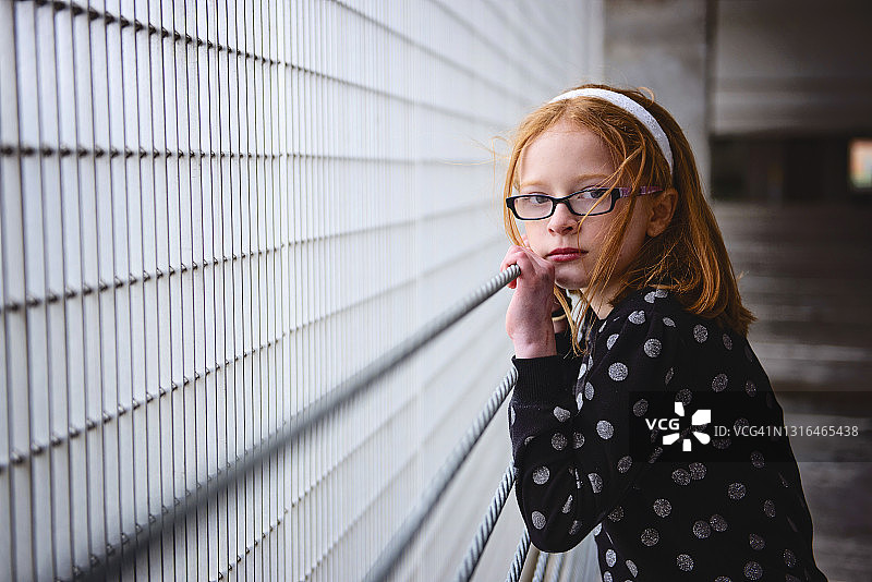 在停车场里拥有红色头发的孤独悲伤少女图片素材