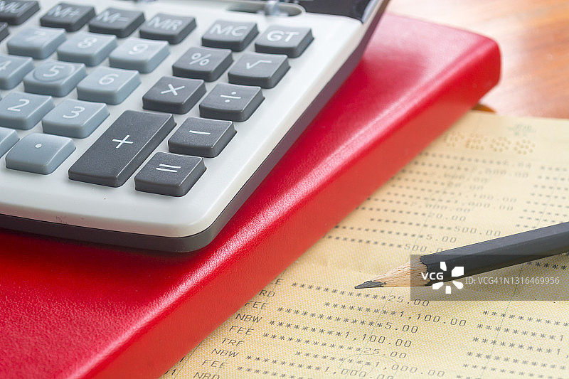 计算器、书本和铅笔俯视特写，用于计算和规划退休生活方式的每月家庭支出图片素材