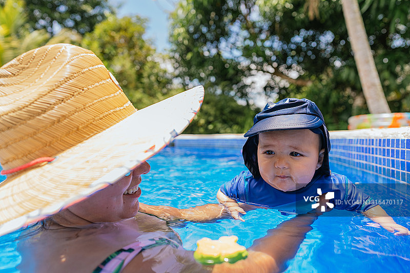 宝宝在游泳池里和妈妈玩耍图片素材