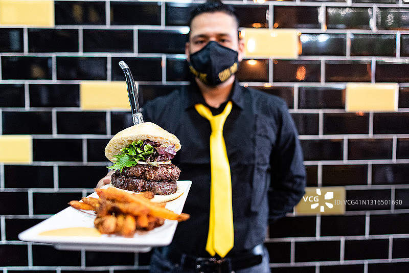 侍者手持双层汉堡图片素材