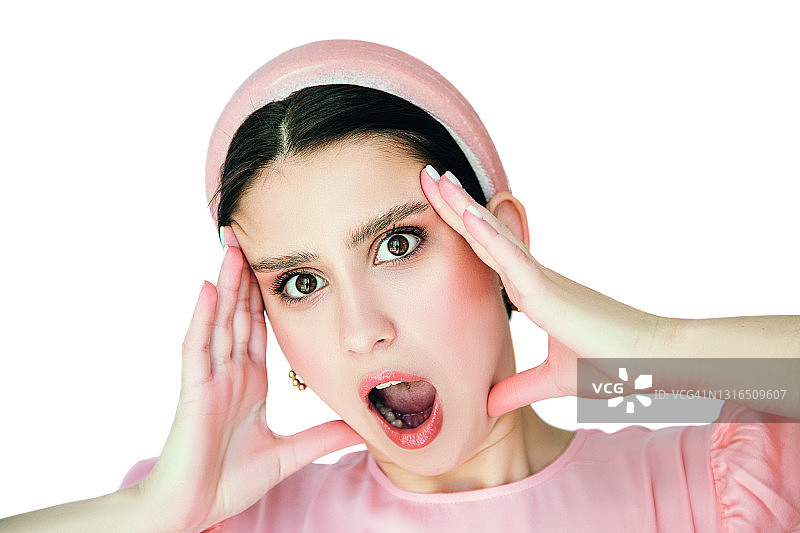 惊讶的漂亮女孩捂住头部，张着嘴的特写肖像图片素材
