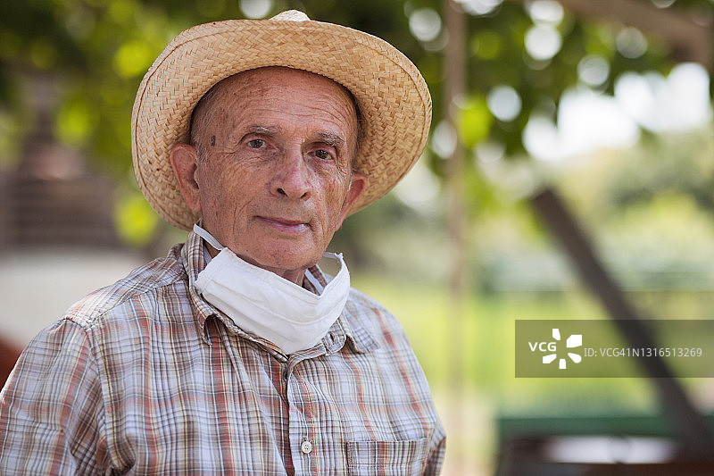 脖子上戴着面罩，头上戴着草帽的男人图片素材