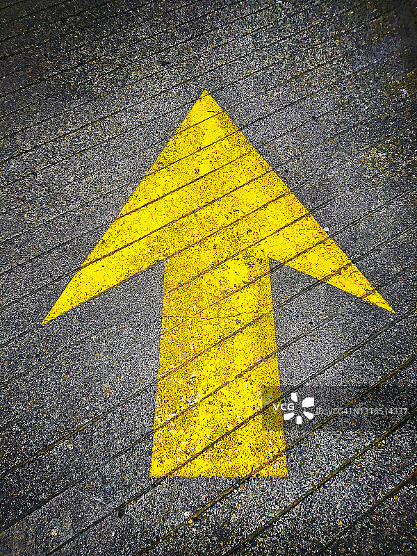 沥青路上向上指向的黄色油漆方向箭头图片素材