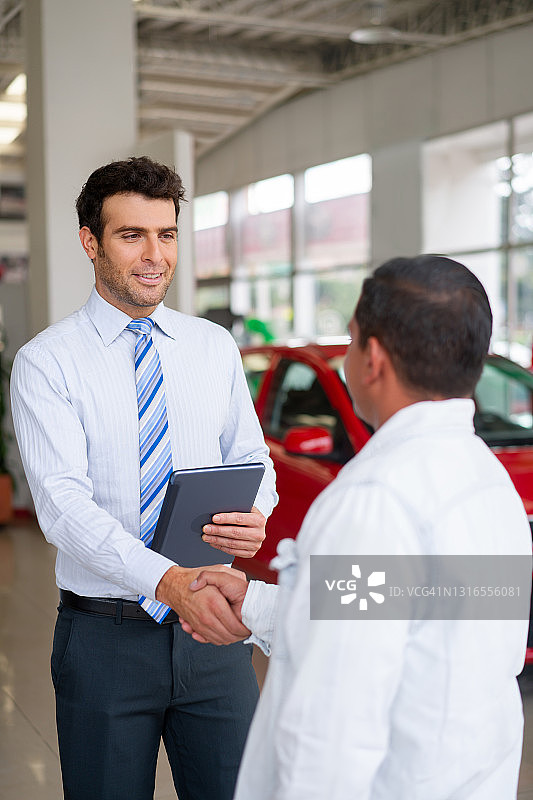 推销员在经销店与顾客握手图片素材