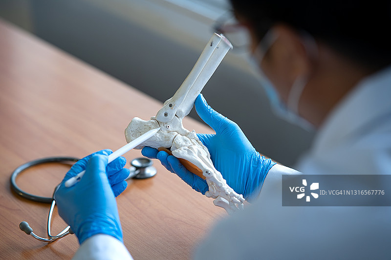 骨科医生在他的办公室里与病人和模型图片素材