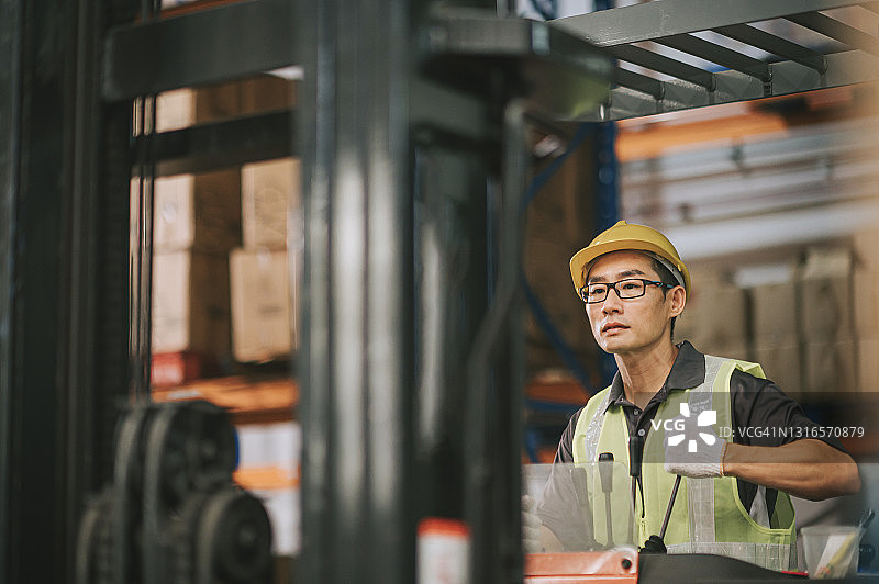 在工厂操作叉车的亚洲工人图片素材