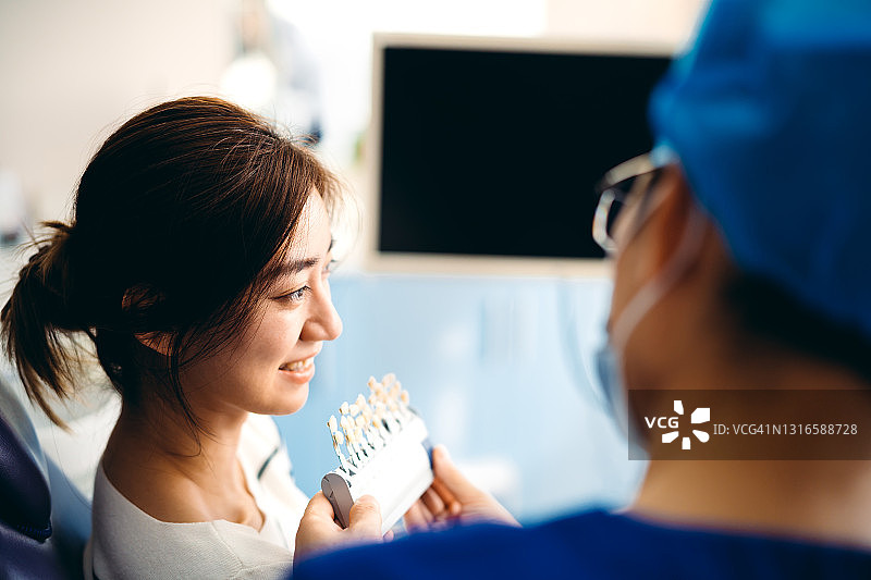 年轻亚裔女性在牙科诊所接受牙科治疗图片素材