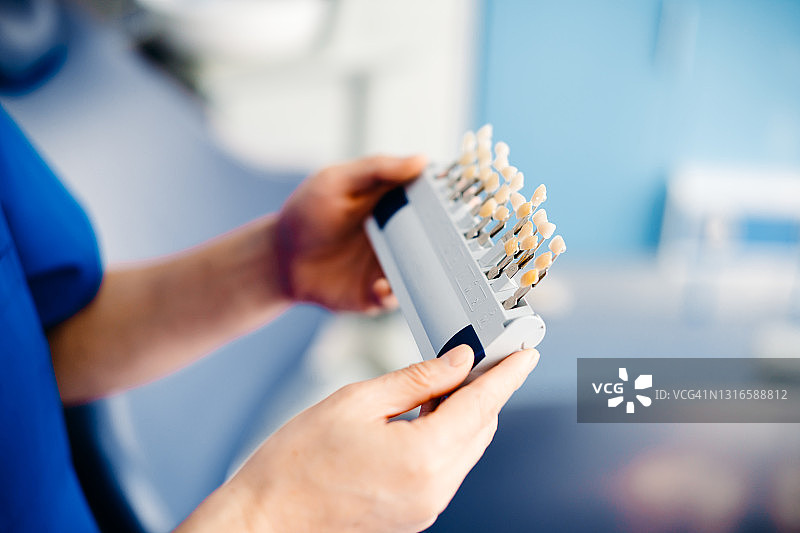 亚洲牙医拿着牙齿比色板图片素材