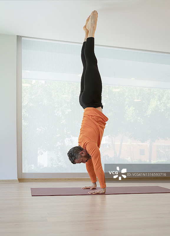 在瑜伽馆练习瑜伽的中年男人图片素材