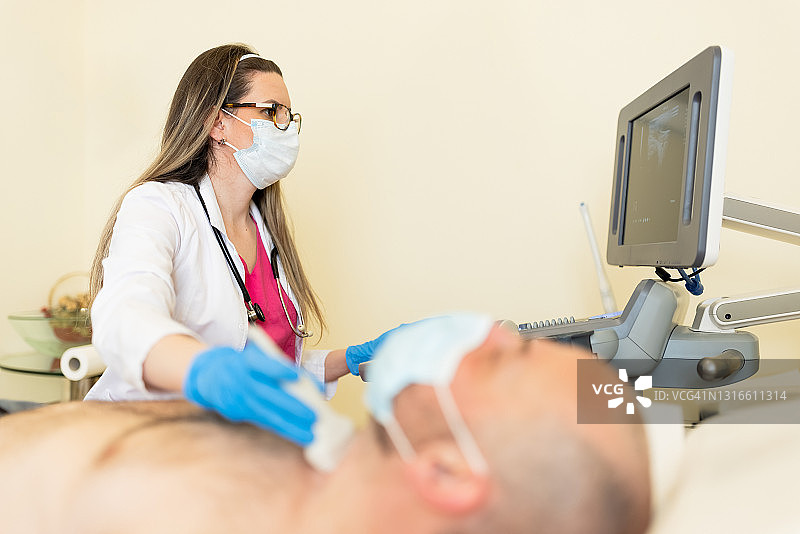 中年男性患者进行甲状腺超声检查图片素材