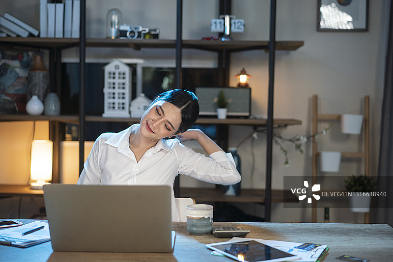 疲倦的女人在办公室工作到深夜图片素材