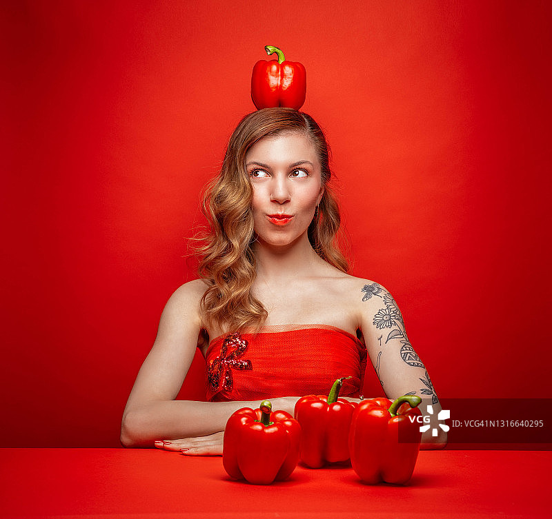 头顶红辣椒的年轻女子图片素材