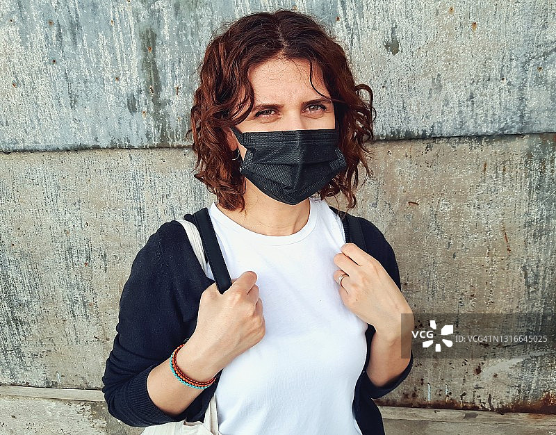 疫情期间戴防护口罩的年轻女子看着镜头图片素材