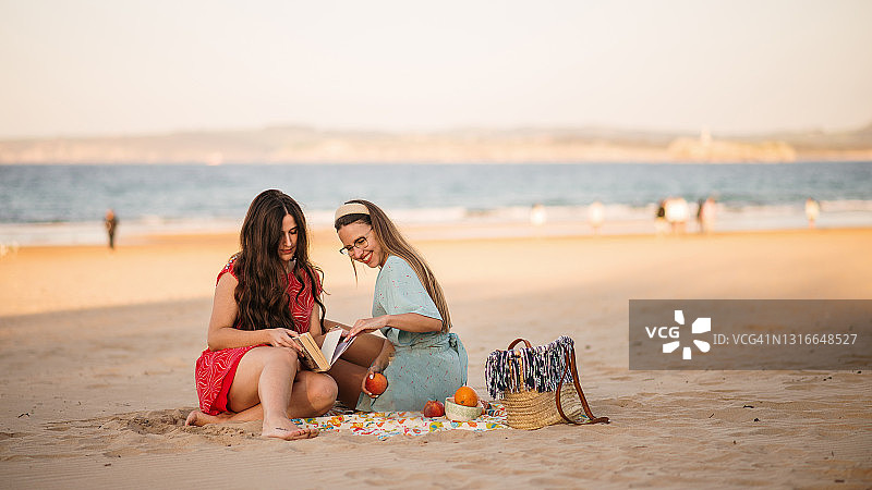在海滩上共度时光的两位年轻女人图片素材