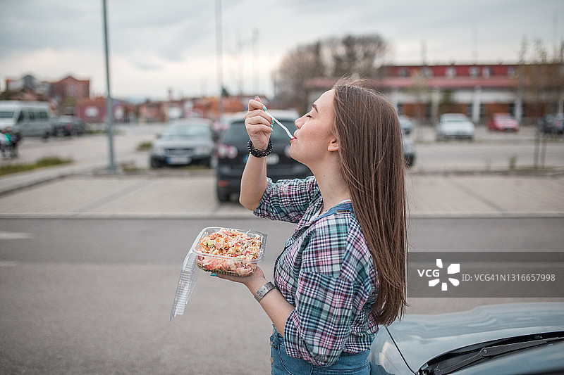 吃塑料盒沙拉的美丽女人图片素材