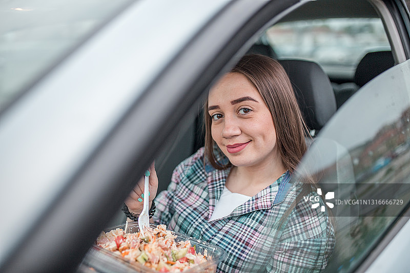 年轻女子在车内吃沙拉图片素材