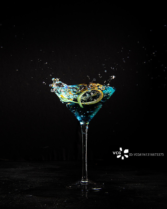 蓝色马提尼酒，橙片飞溅图片素材