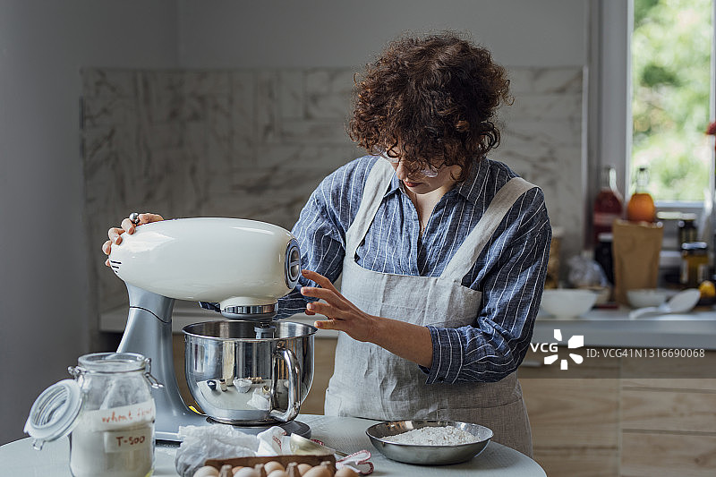 年轻女人用立式搅拌机制作饼干面团图片素材