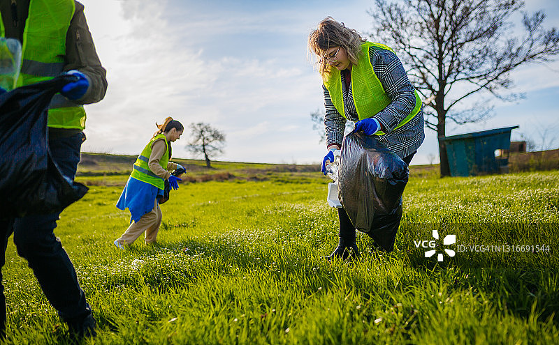 女人和一群志愿者一起清理大自然图片素材
