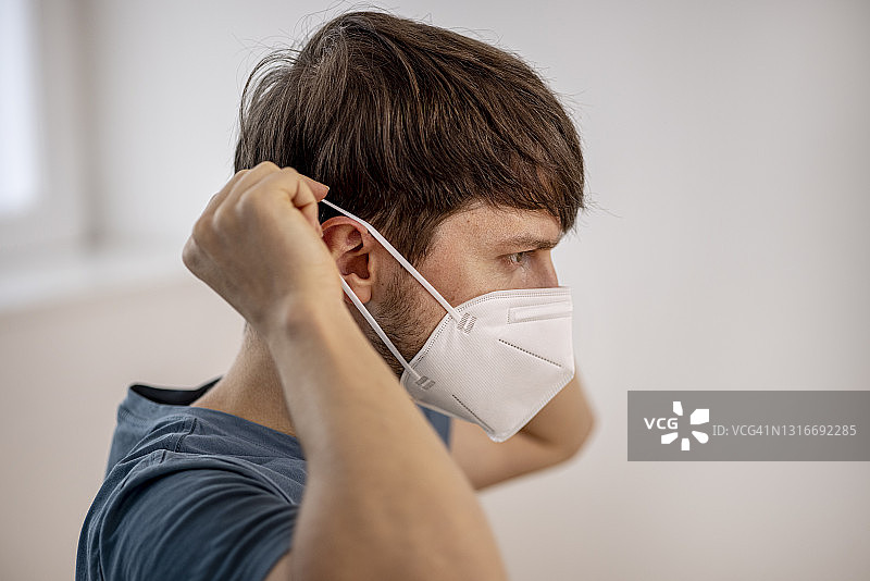 戴FFP2防护口罩的年轻男人肖像图片素材