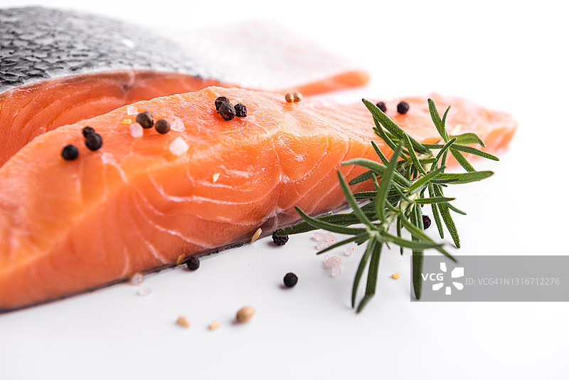 新鲜三文鱼鱼柳：白色背景上的生三文鱼柳、胡椒盐、莳萝和迷迭香图片素材