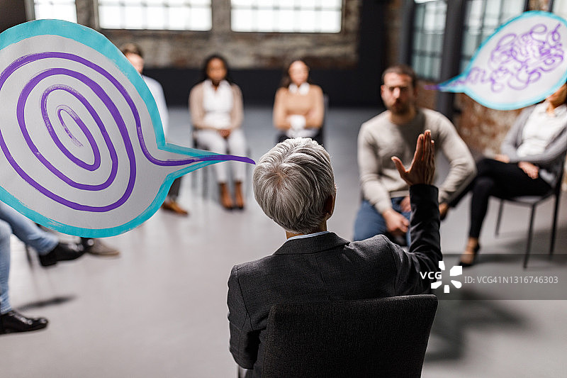 精神科医生在集体治疗中整理病人头部混乱的后视图图片素材