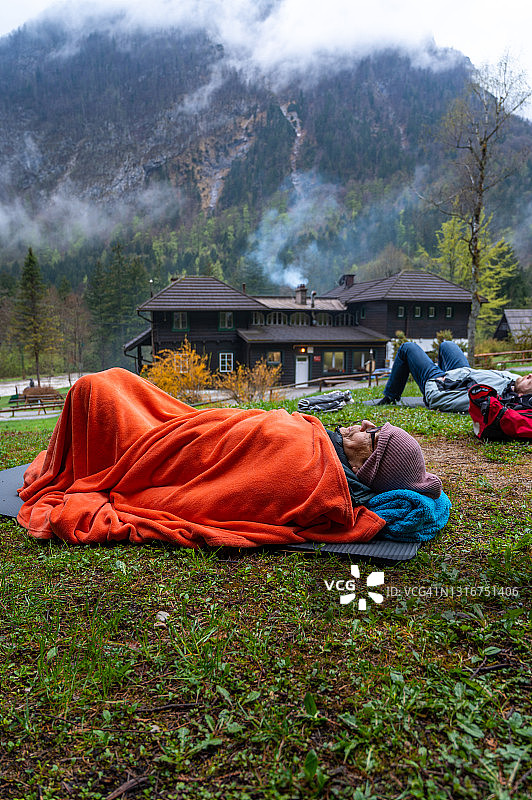 年长女性和年轻成年男子躺在户外图片素材