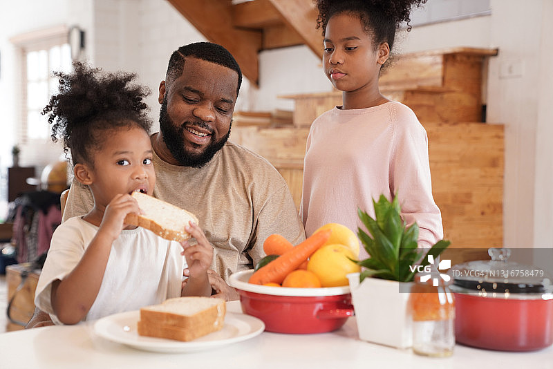 父亲照顾两个女儿并一起享用早餐图片素材