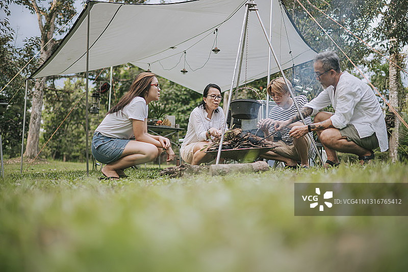 中国家庭与两个成年子女一起准备篝火并准备做饭图片素材