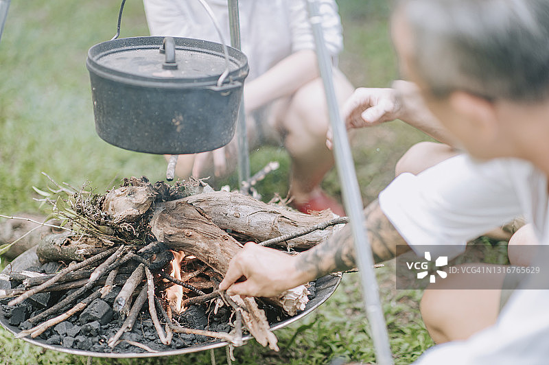 亚洲人在野外用柴火和铁锅炖汤做饭图片素材