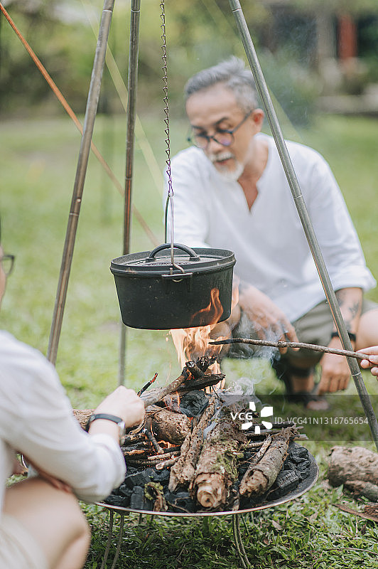 中国老人和家人准备篝火做饭图片素材
