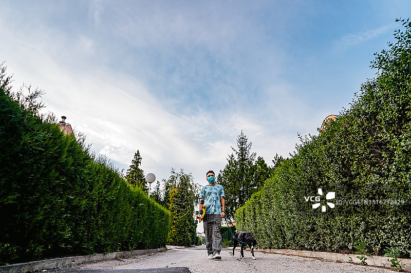 玩滑板的男人遛狗图片素材