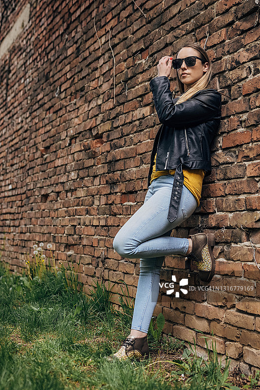 砖墙旁的现代女性图片素材