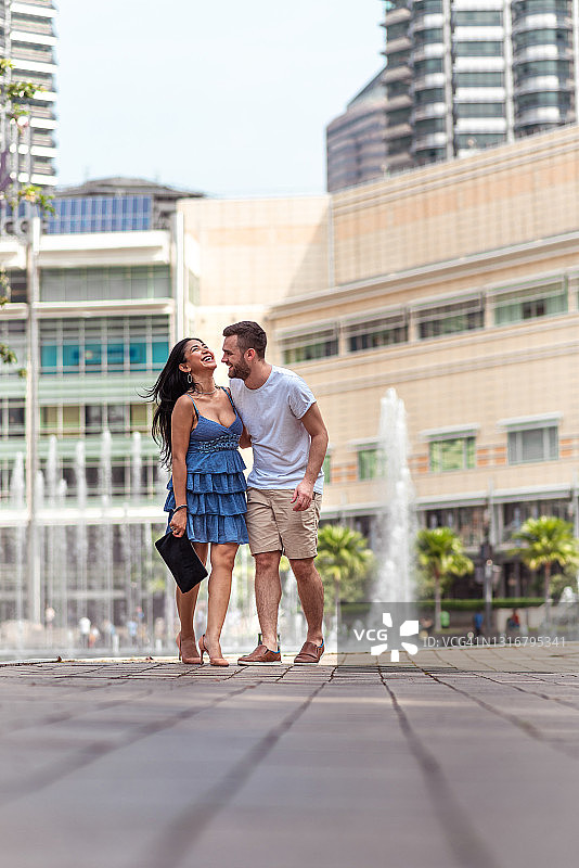 快乐情侣在城市步行街散步图片素材