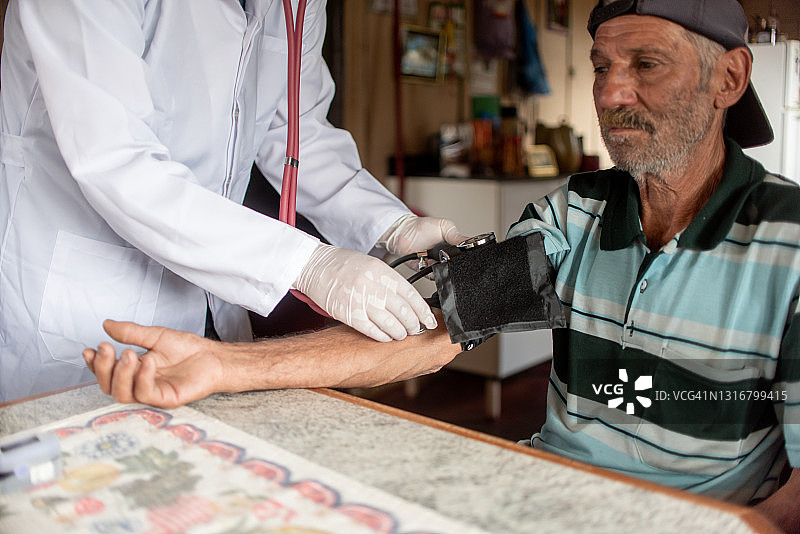 医生在家中为老年人测量血压图片素材
