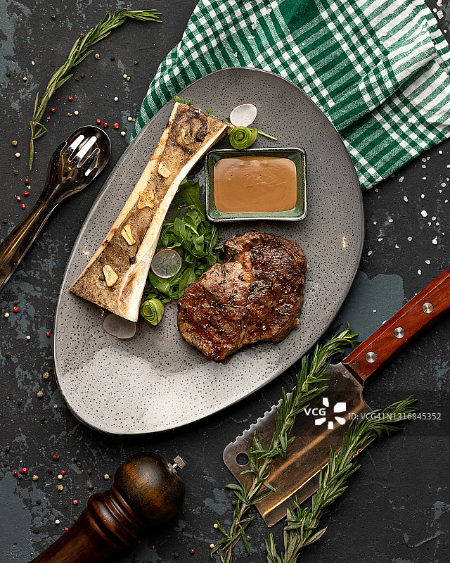 黑色桌子上带有厨房用具的多汁炸肉片和蔬菜，顶视图图片素材