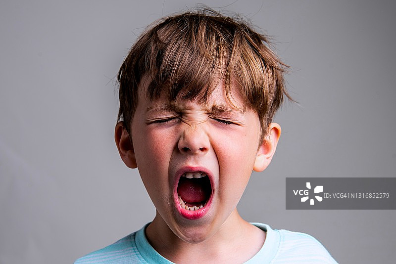 在灰色背景下哭泣的白人小男孩图片素材
