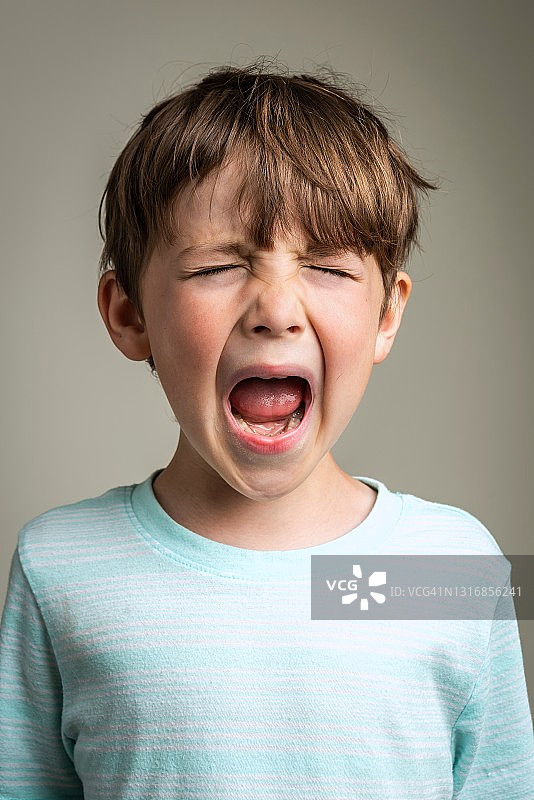在灰色背景下哭泣的白人小男孩图片素材
