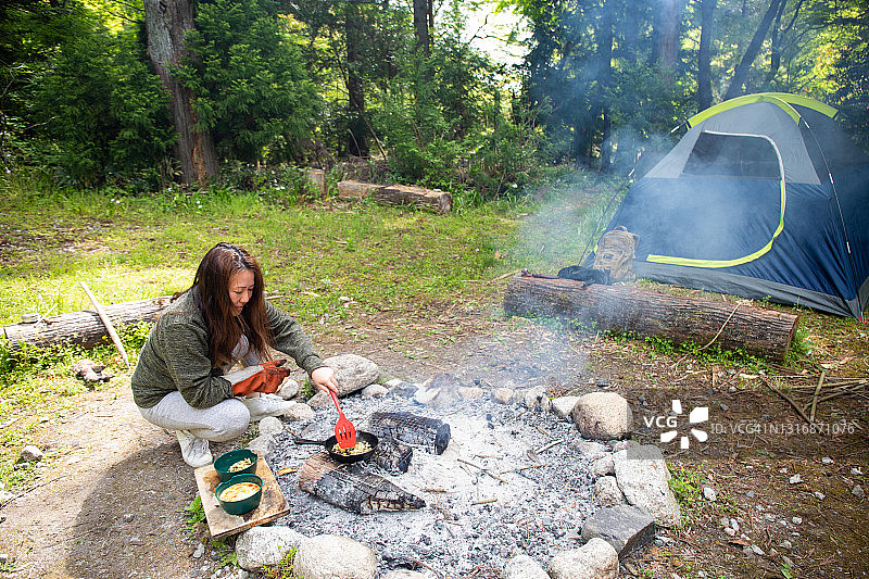 在荒野中篝火烹饪的女人图片素材