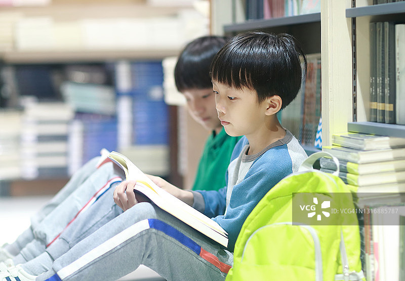 快乐的亚洲儿童在图书馆看书图片素材