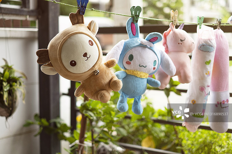 晾衣绳上晾晒的湿玩偶特写图片素材