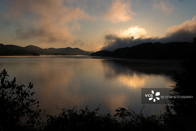 日出时宁静的湖面上的薄雾图片素材