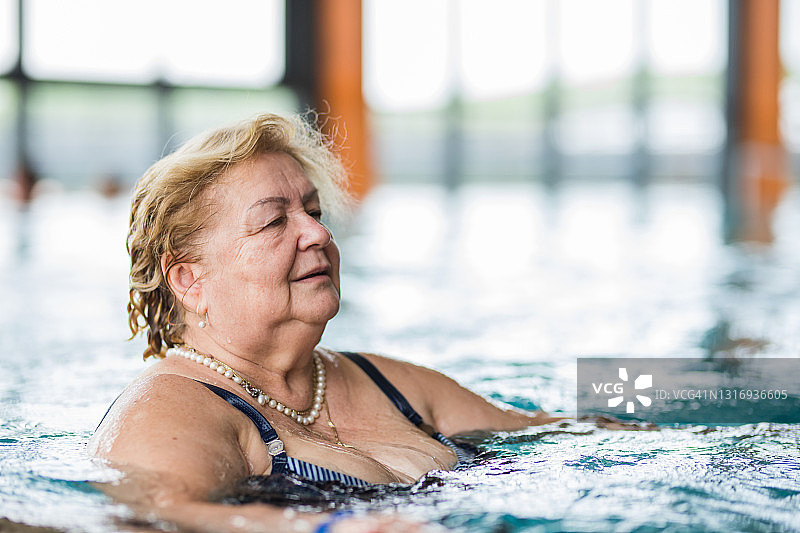 在游泳池里享受水的放松女人图片素材