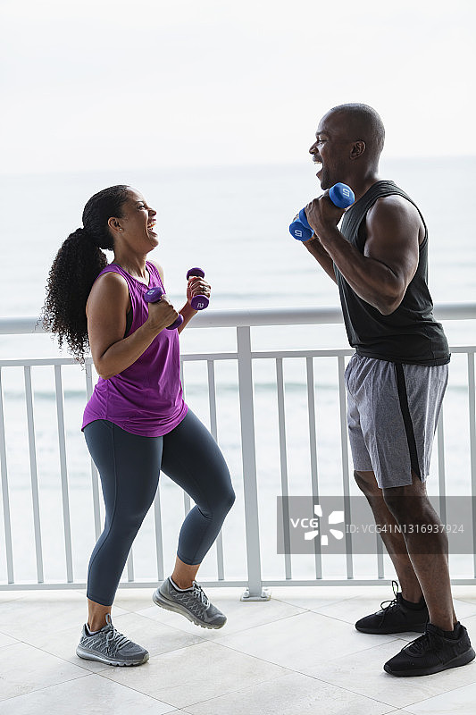 情侣在阳台上用哑铃锻炼图片素材