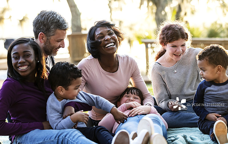 在公园里欢笑的五孩混合家庭图片素材